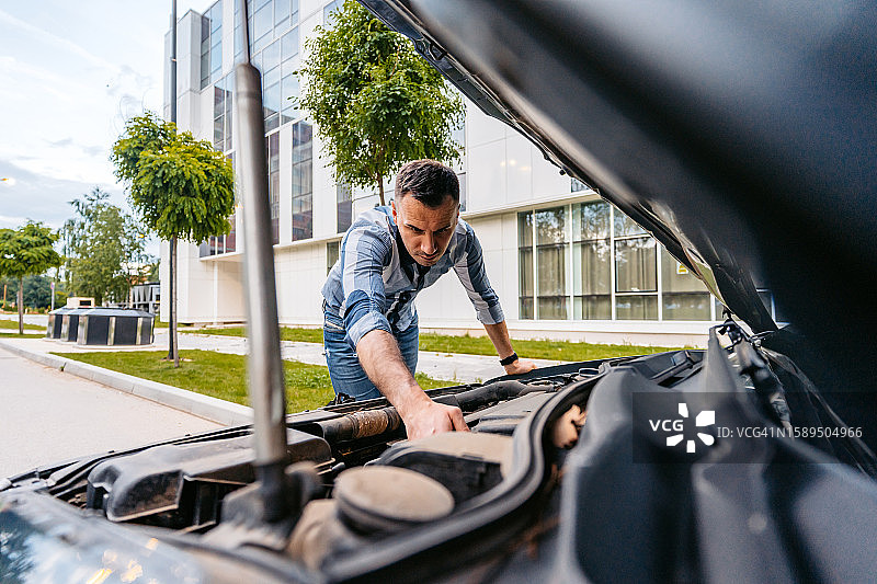 年轻男人在街上遇到汽车故障图片素材