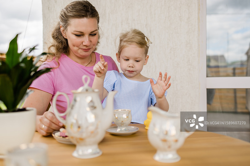 在露台上品茶：妈妈和女儿的茶话会图片素材