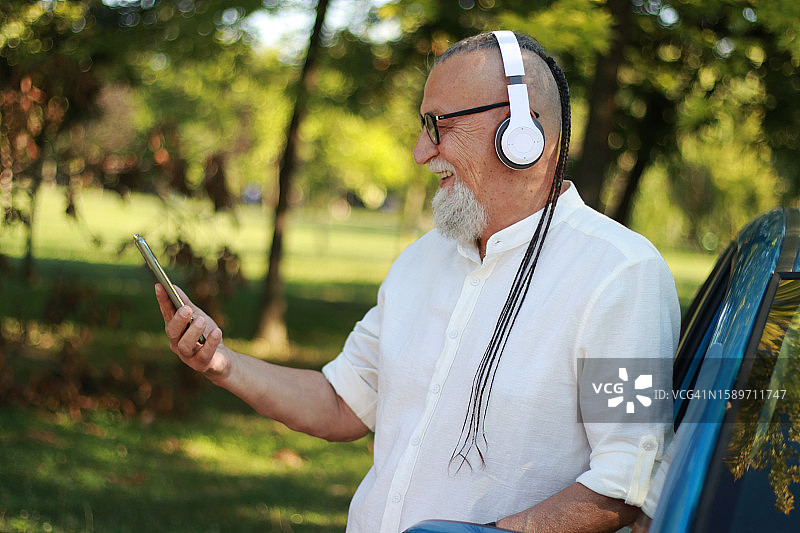 戴着耳机的现代老人听音乐图片素材