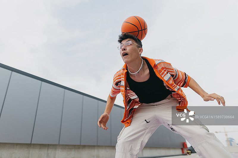 户外做篮球技巧的时尚Z世代男孩肖像图片素材