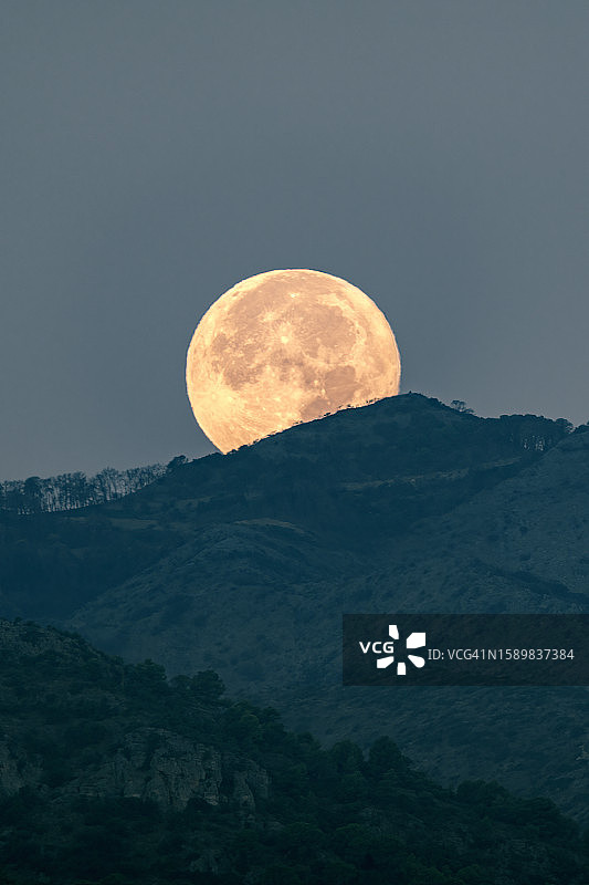 消失在山峰中的满月，月亮的黎明图片素材