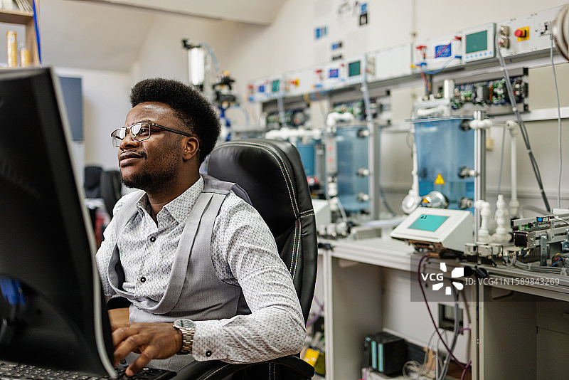 在机械实验室用键盘打字的工程师图片素材