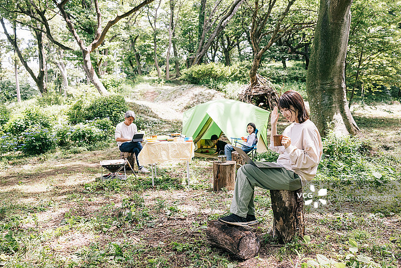 日本母亲在露营地进行工作视频通话图片素材