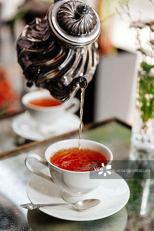 下午茶仪式中向茶杯里倒茶图片素材