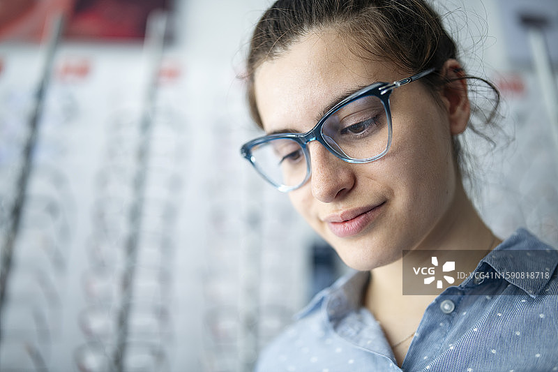 女士在眼镜店试戴新眼镜的肖像图片素材