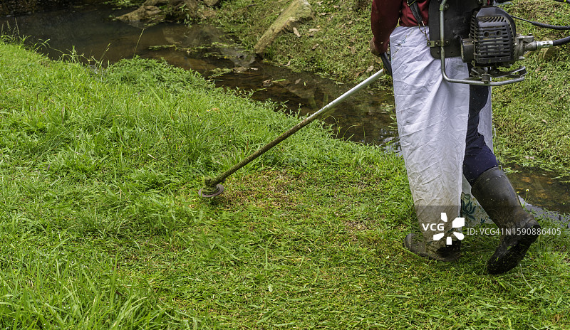 戴安全设备的园丁修剪草坪图片素材