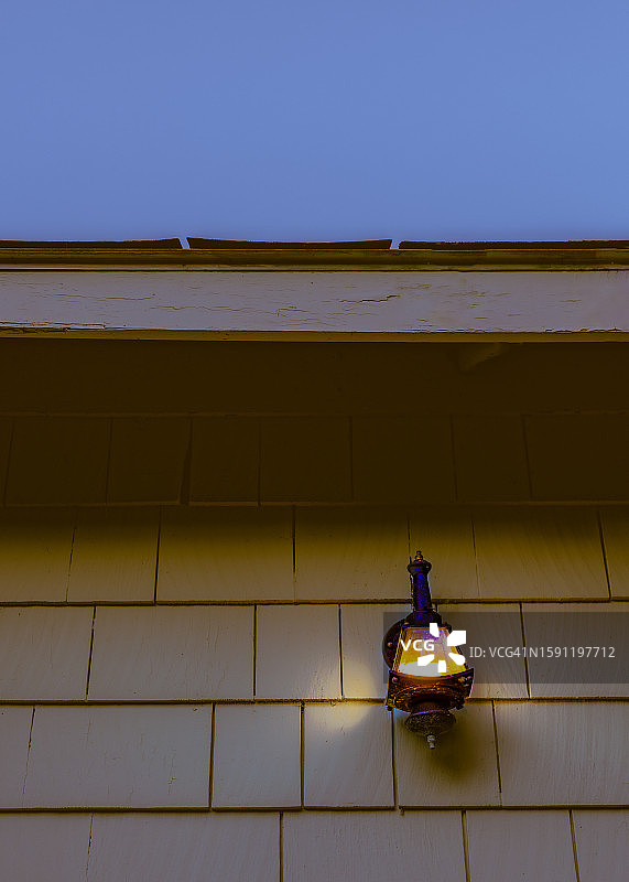 经典木瓦外墙上的户外照明古董壁灯（可见天空）图片素材