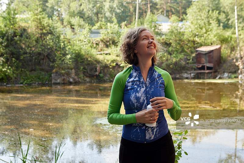 在自然环境中手拿环保瓶散步的女人图片素材