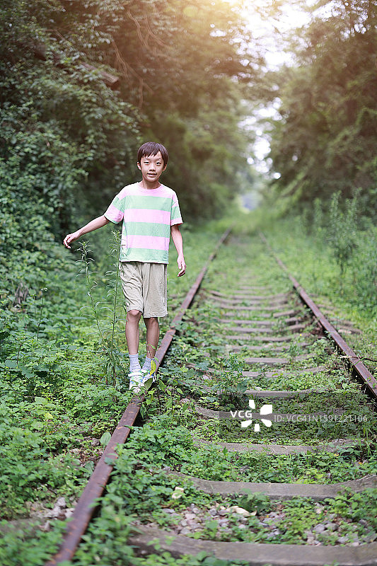 男孩在铁轨上行走图片素材