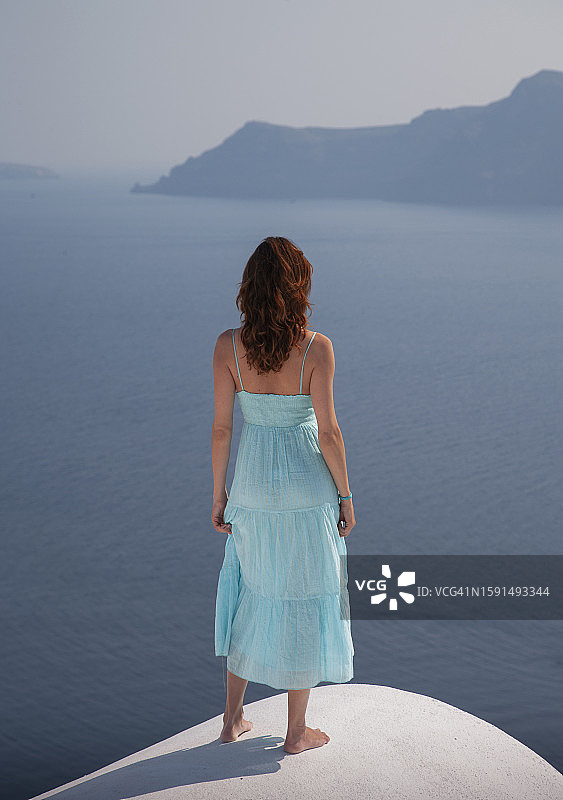 希腊圣托里尼岛上的年轻女人图片素材
