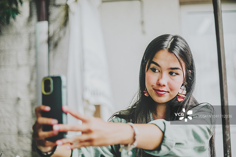 年轻女人对着镜头微笑自拍图片素材
