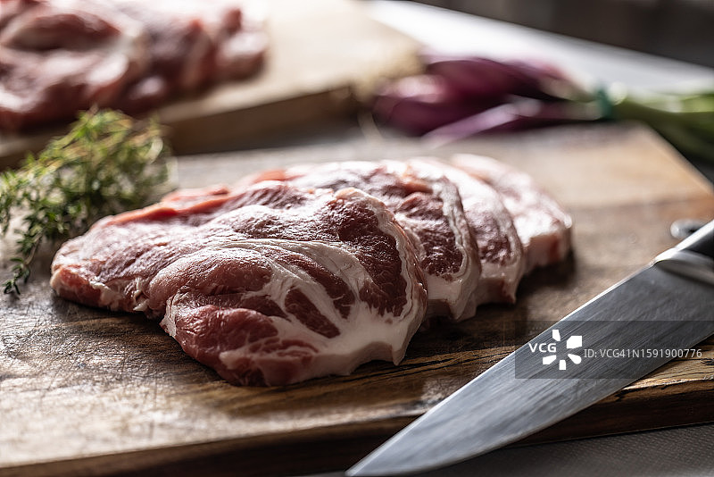 切板上切好的猪颈肉块与百里香图片素材