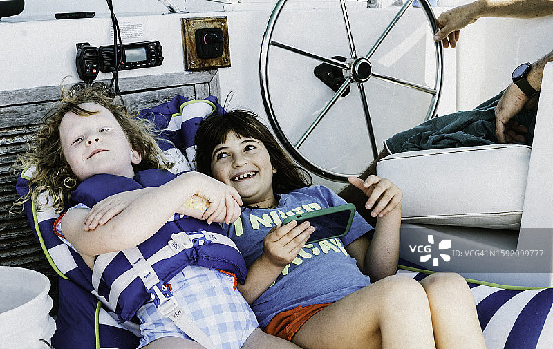 快乐的年轻孩子们在船上、帆船或游艇上度过一天图片素材