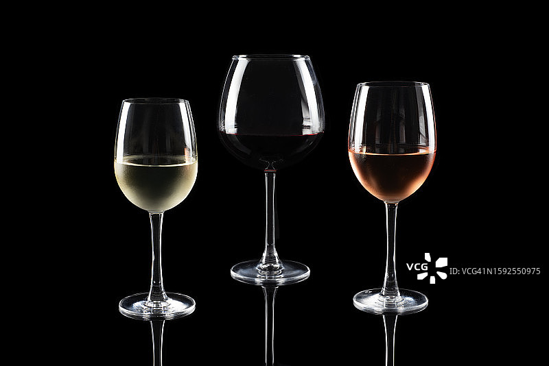黑色背景上的红、白、桃红葡萄酒图片素材