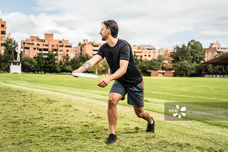 年轻人在公园里扔飞盘图片素材