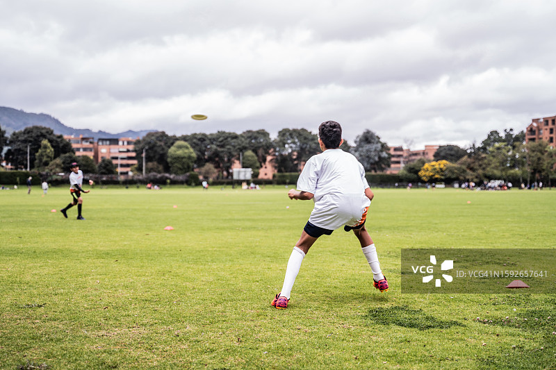 男孩和朋友在公园里玩飞盘图片素材