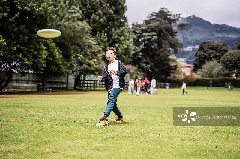 儿童在公园里扔飞盘图片素材