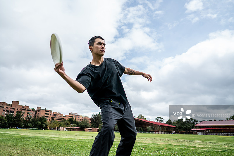 年轻人在公园里扔飞盘图片素材
