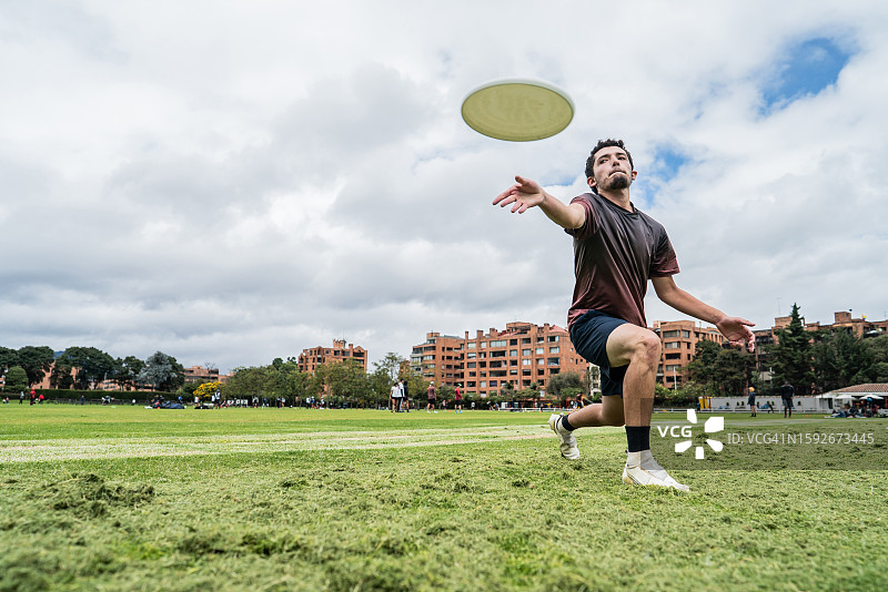 年轻人在公园里扔飞盘图片素材