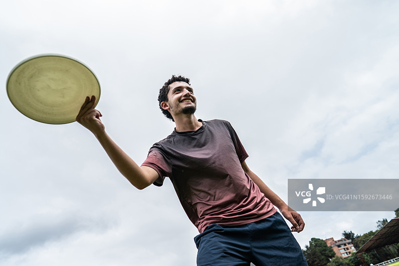 年轻人在公园里扔飞盘图片素材