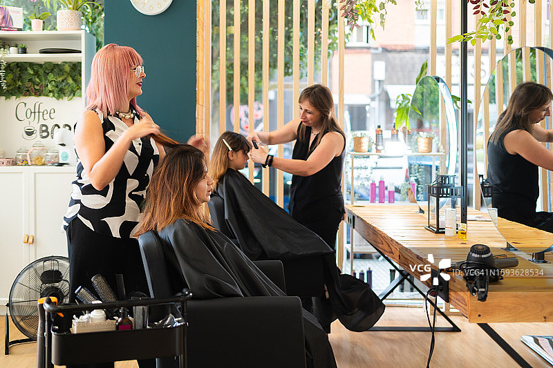 在美发沙龙工作的理发师团队图片素材