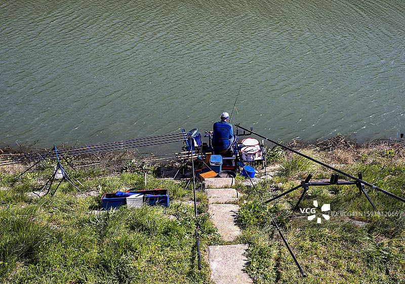 河岸边垂钓鲤科鱼类的渔民图片素材