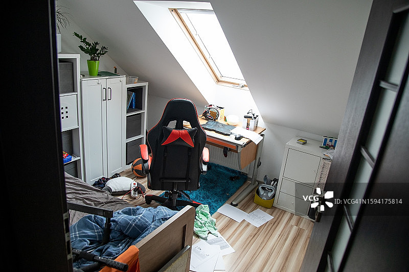 青少年的世界：阁楼房间里未整理的床铺和散落的盘子图片素材