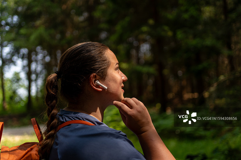 戴无线耳机在户外享受生活的年轻漂亮女子图片素材