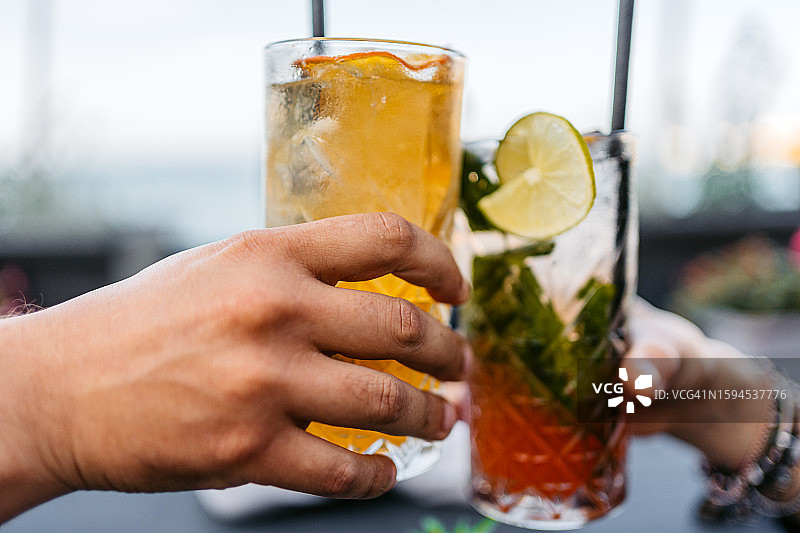 情侣在海滨咖啡馆用鸡尾酒敬酒图片素材