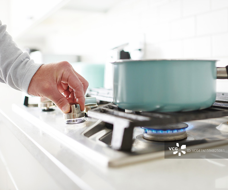 不确定身份的男人在燃气灶上做饭图片素材