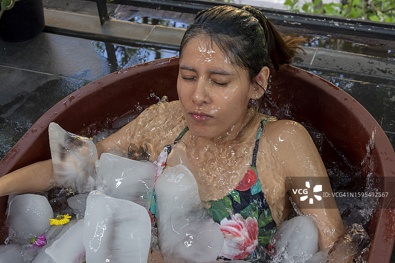 女人在进行冷冻疗法时从冰浴缸中出来图片素材