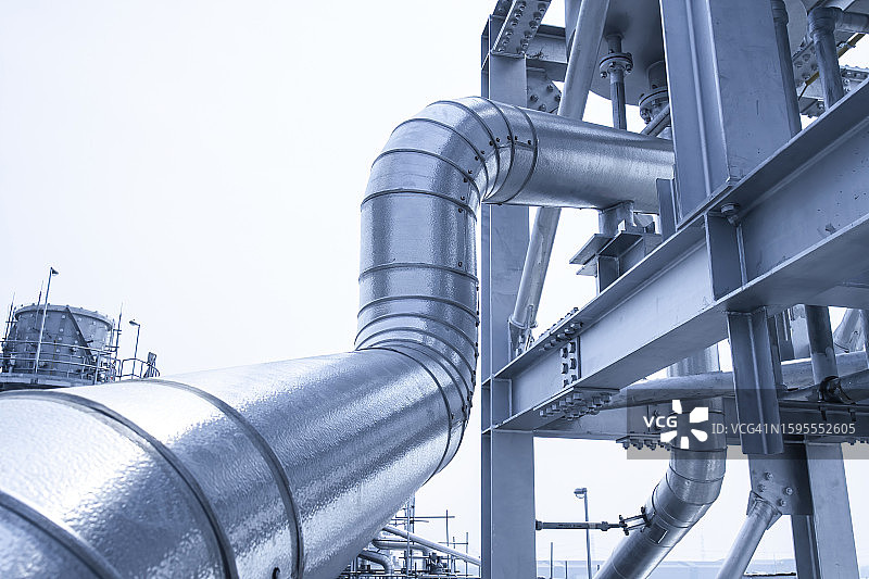 工业工厂中带有绝缘和设备的钢制管道图片素材