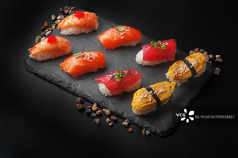 黑色背景上的各种手握寿司图片素材