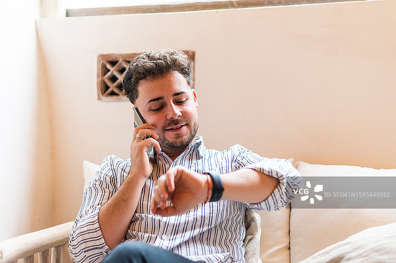 商人在用手机通话时查看手表图片素材