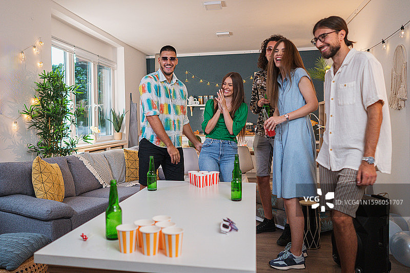 在家庭聚会上玩啤酒乒乓球的白人朋友图片素材