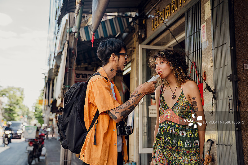 一对亚洲夫妇在周末市场吃泰国甜点图片素材