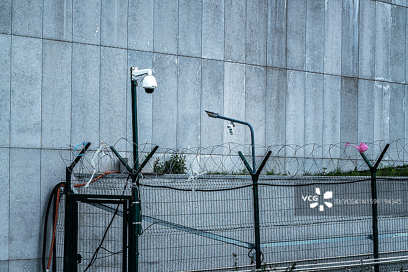 带刺铁丝网和安全摄像头。带有刀片的监狱或边界围栏。安全概念图片素材