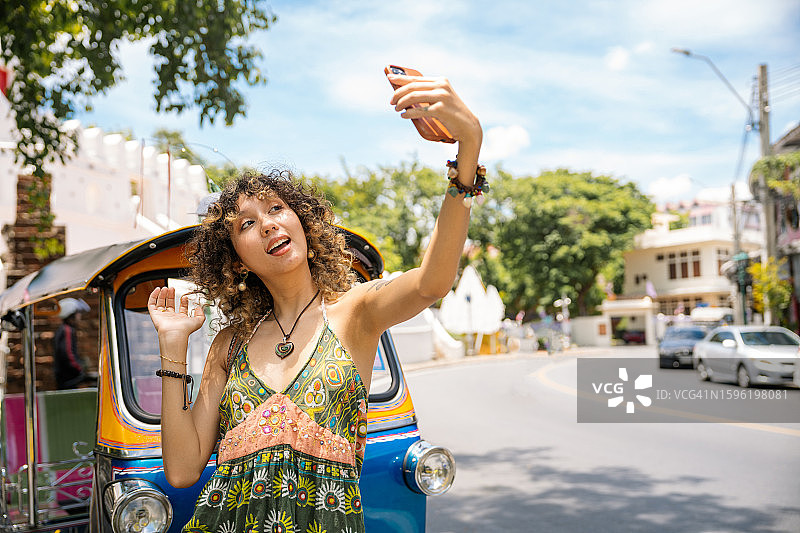 在曼谷市中心旅行的亚洲年轻女性，手持复古相机图片素材
