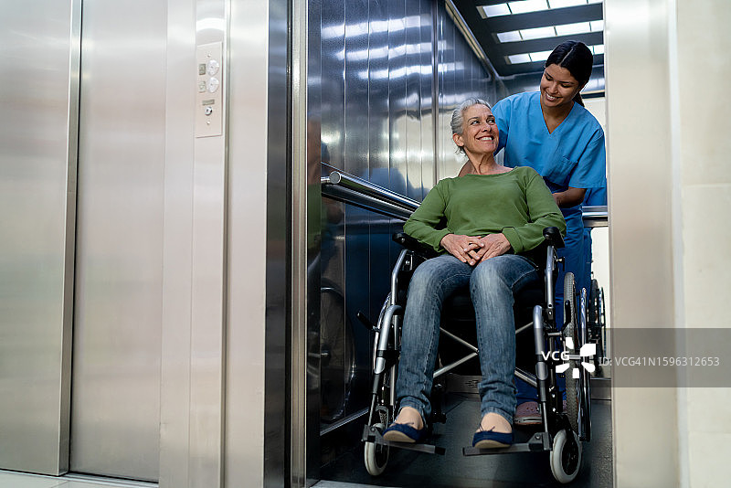 女护士用轮椅送老年女病人去医院做医疗检查图片素材