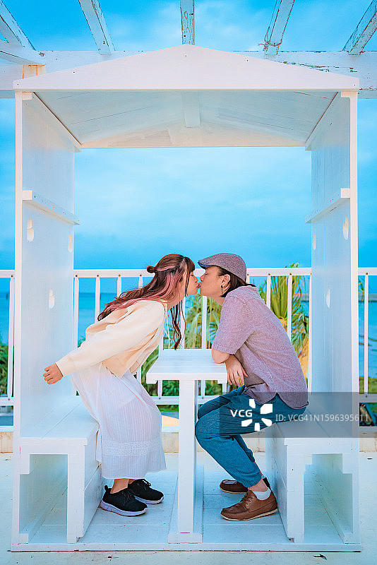 一对情侣在白色凉亭内互动图片素材