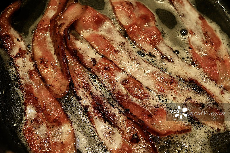 煎锅里滋滋作响的培根图片素材