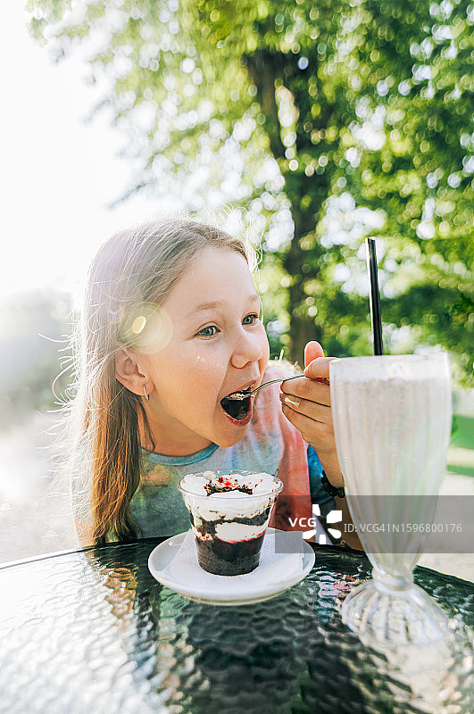 儿童在路边咖啡馆吃蛋糕图片素材