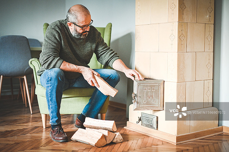 中年男人点燃壁炉图片素材