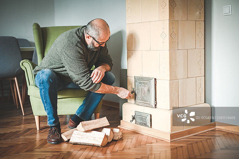 中年男人点燃壁炉图片素材