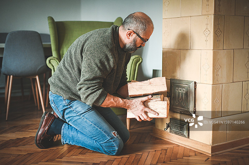 中年男人点燃壁炉图片素材