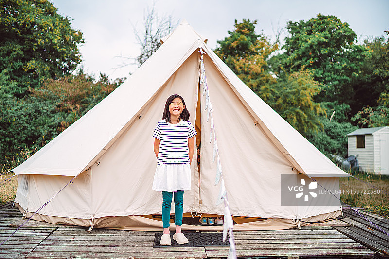 在野营地冰屋帐篷外对着镜头快乐微笑的青少年女孩图片素材