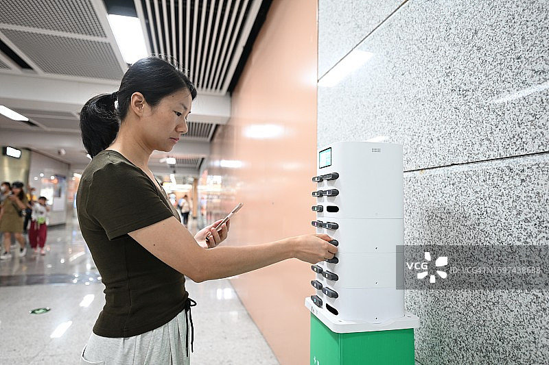 女子用手机扫描二维码租借充电宝图片素材