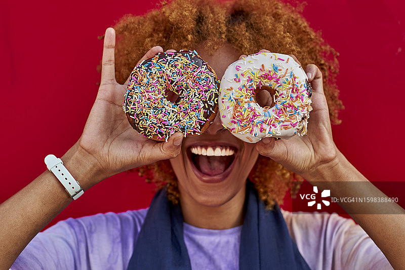 俏皮的女人拿着两个甜甜圈图片素材
