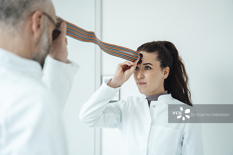 科学家假装连接墙前的彩色电脑线图片素材