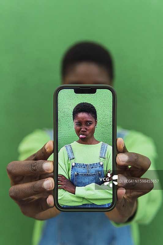 年轻女人在智能手机上展示照片图片素材